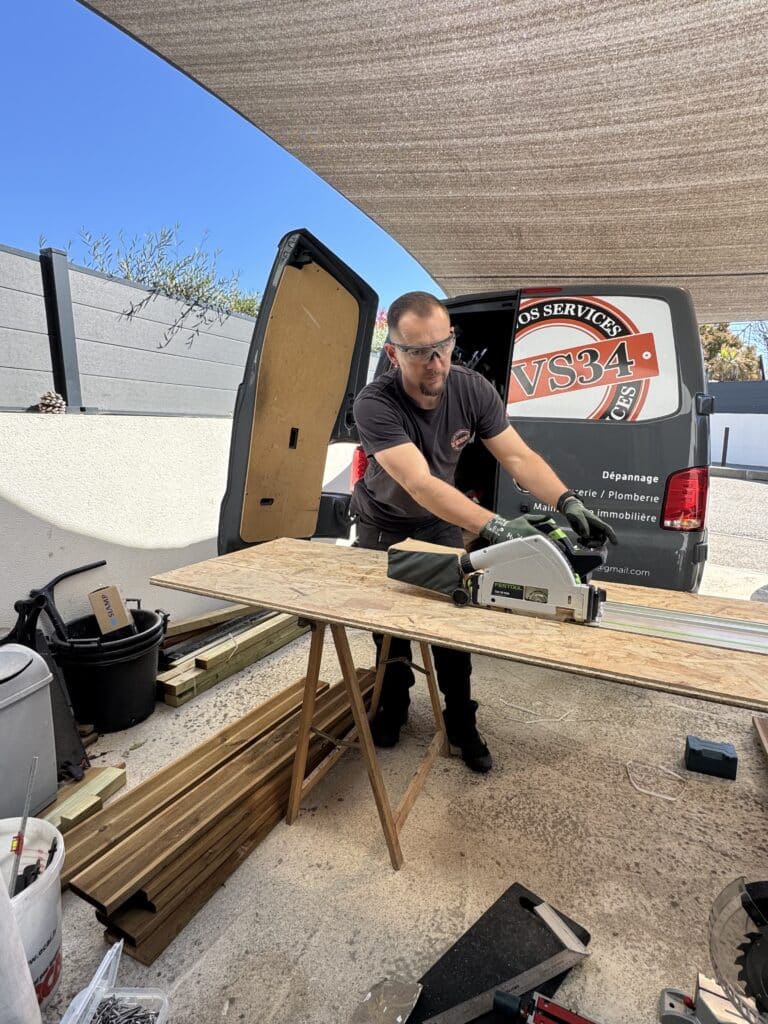Menuisier utilisant une scie Festool pour couper du bois OSB devant son van OS SERVICES VS34.
